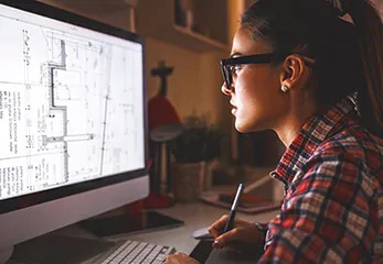 eine junge Frau vor einem Bildschirm mit einem CAD Plan
